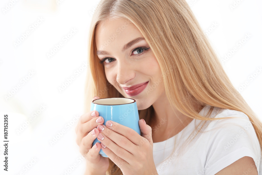 Young beautiful smiling woman with cup of coffee on white background Young beautiful smiling woman with cup of coffee on white background