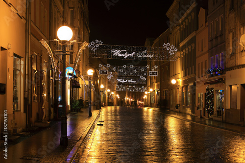 Ulica w centrum miasta Brzeg w nocy po deszczu w złotym kolorze.
