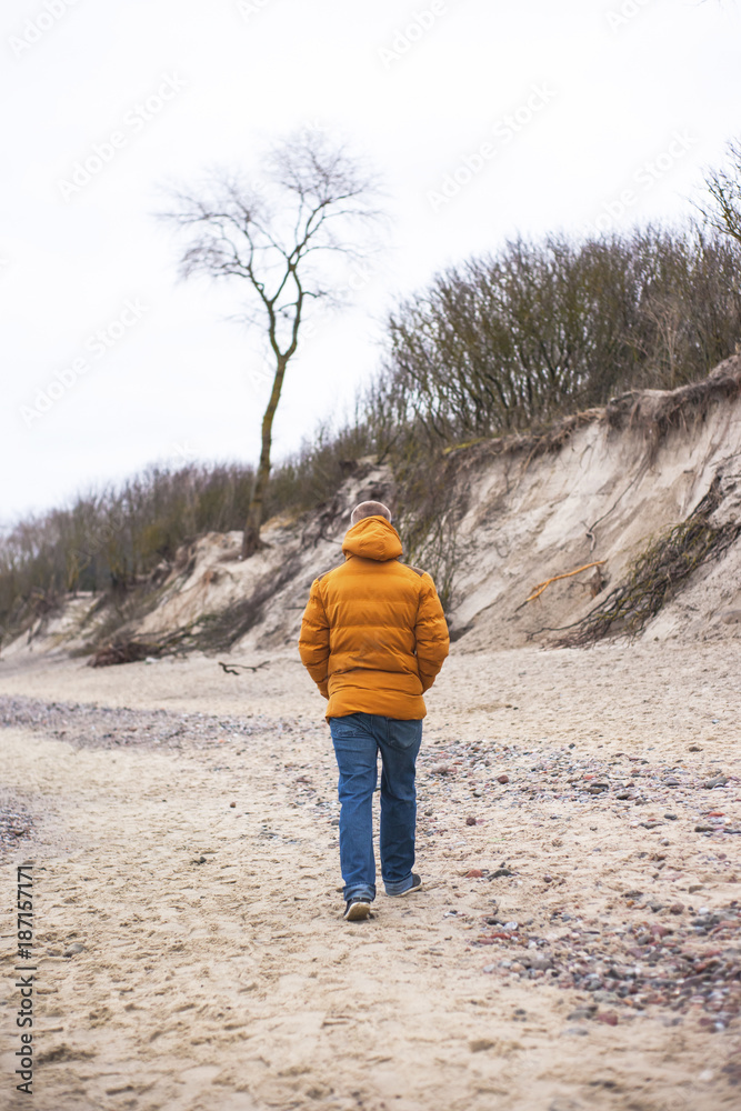 lonely guy walking on the winter beach lonely guy walking on the winter beach