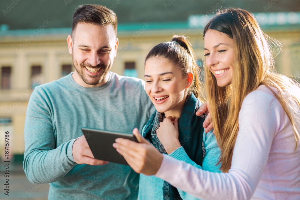 Group of smiling friends with digital tablet outdoor Group of smiling friends with digital tablet outdoor