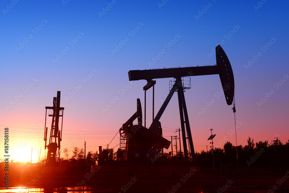 Is operation of the pumping unit in oilfield sunset, close-up