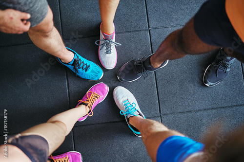 Diverse people wearing running shoes standing in a gym