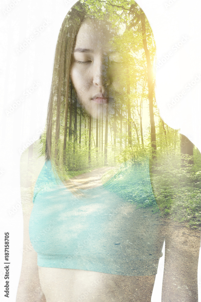 Portrait of a young woman with the effect of double exposure. Combination of a picture of nature and a young woman.
