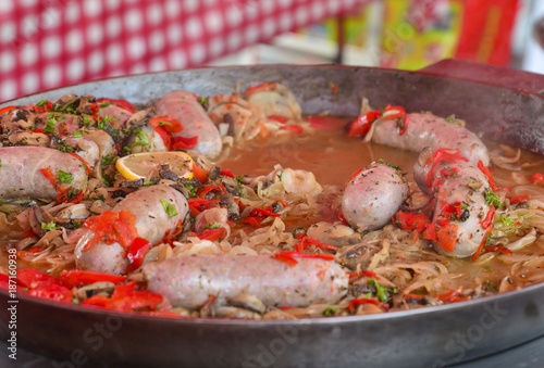 Big pan of andouillettte dish with the vegetables on a market