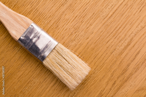 mayal brush with natural nap and wooden handle lies on a wooden oak desk photo