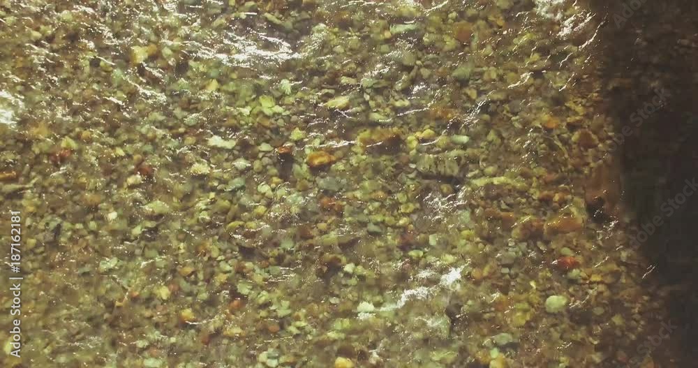 Aerial UHD 4K view. Mid-air flight over fresh and clean mountain river with transparent water and stone river bed at sunny summer morning. Top view and horizontal movement Aerial UHD 4K view. Mid-air flight over fresh and clean mountain river with transparent water and stone river bed at sunny summer morning. Top view and horizontal movement