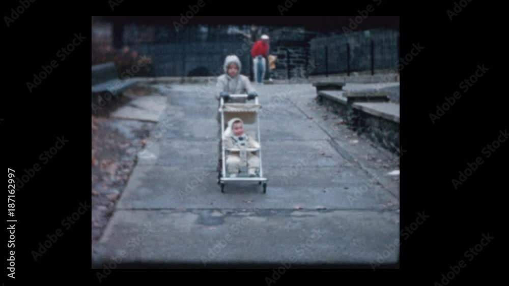 1960 Young boy pushes baby brother in vintage antique stroller Stock ...