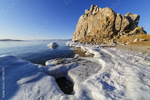 Shore of ice-covered mountains in the background and water