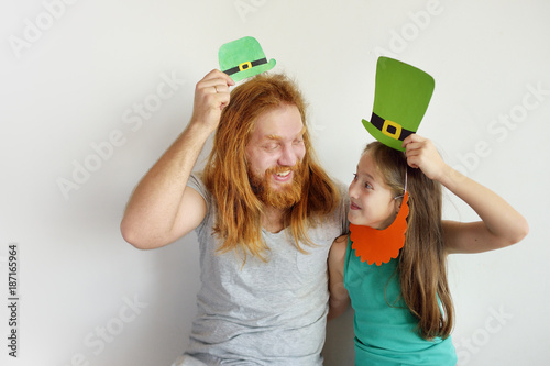 The father with the daughter try on masks for a St. Patrick's Day