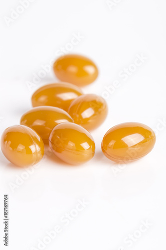 Fish oil capsules isolated on white. Round yellow pills. 