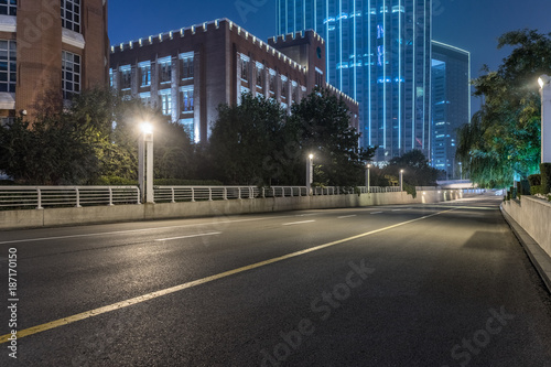 empty asphalt road and modern buildings at night
