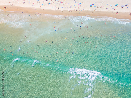 Photography An aerial view looking down at people swimming at the beach in summer with blue