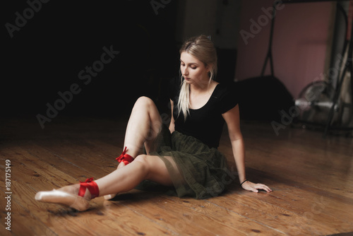 Beautiful ballerina sitting on floor