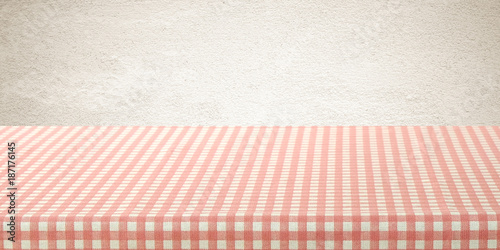 Empty table cover with pink and white tablecloth over brown wall background, banner, table top, counter design for food and product display montage