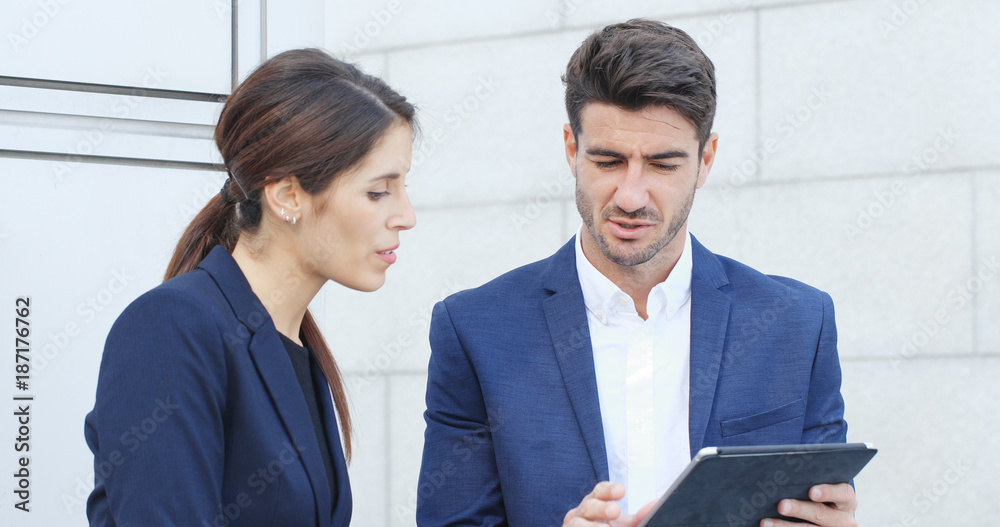 Business people discuss on tablet computer together Business people discuss on tablet computer together