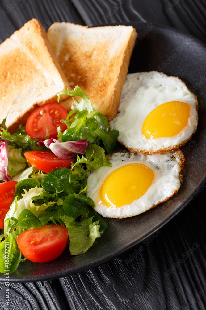 healthy breakfast of fried eggs with fresh vegetable salad and toast close-up. vertical