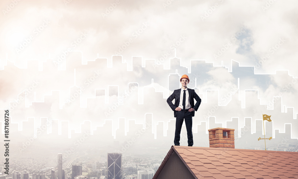 Engineer man standing on roof and looking away. Mixed media