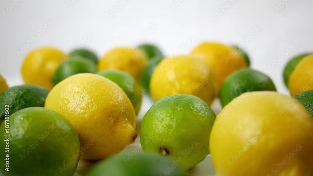 Vibrant Limes and Lemons spinning over white backdrop Vibrant Limes and Lemons spinning over white backdrop