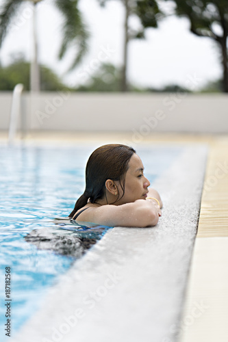 Asia woman relaxing on a spa's swimming pool.