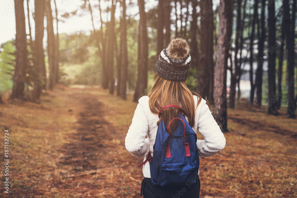 Young woman traveler walking in the forest