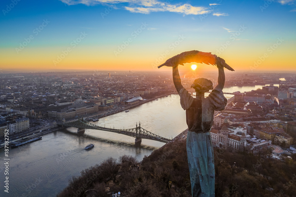 Fototapeta premium Budapeszt, Węgry - Panoramiczny widok z lotu ptaka na Statuę Wolności z Mostem Wolności i łodzią widokową na Dunaju ze wzgórza Gellerta