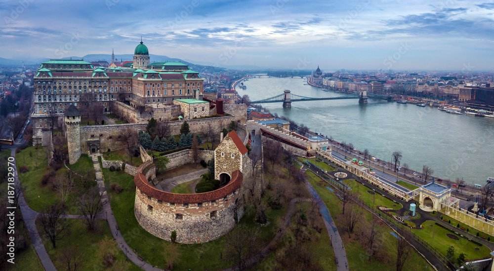 Budapest, Hungary - Aerial drone skyline view of Buda Castle Royal Palace with Szechenyi Chain Bridge and Parliament of Hungary on a cloudy winter day