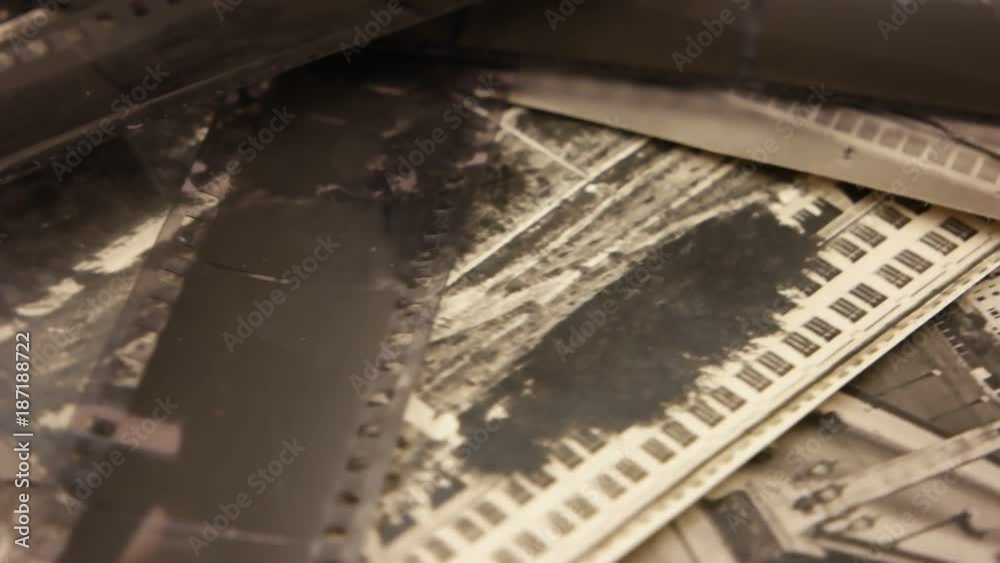 Black- and- white photographic films on the background of old black- and- white photographs Black- and- white photographic films on the background of old black- and- white photographs