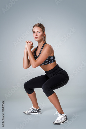 Fitness woman in sports clothing doing sit-ups, studio shot photo