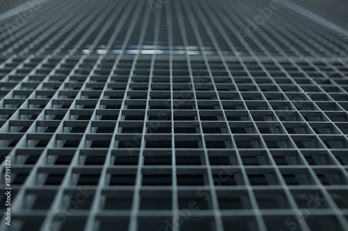 Metal lattice with small cells grid stock background with shallow dof and selective focus © Andrii