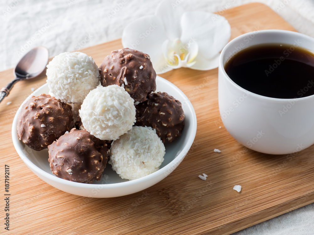 Chocolate and Coconut Candies in a Bowl on a Wooden tray Coffee Cup Orchid. Chocolate and Coconut Candies in a Bowl on a Wooden tray Coffee Cup Orchid.