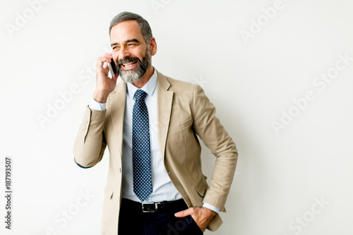 Handsome mature businessman with mobile phone in the office