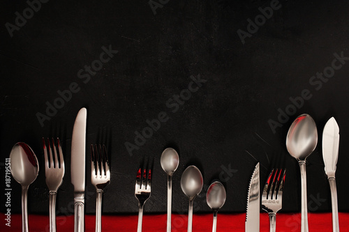 Silver cutlery on black background. food etiquette concept