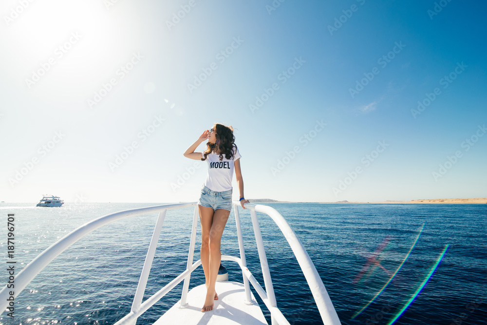 Young beautiful woman sitting on the yacht . Cruise vacation.