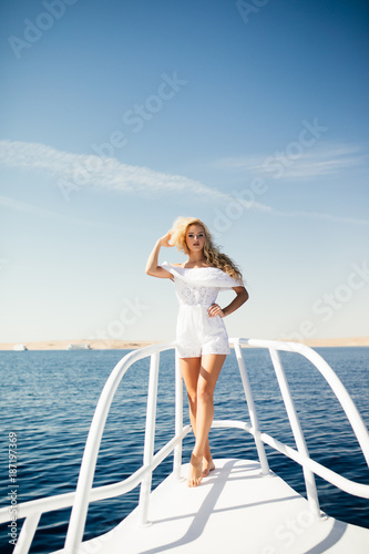 Woman standing on the nose of the yacht at a sunny summer day on sea background © F8  \ Suport Ukraine
