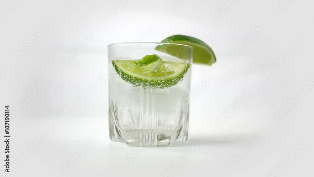 Beautiful Gin and Tonic with Lime spinning over white Beautiful Gin and Tonic with Lime spinning over white