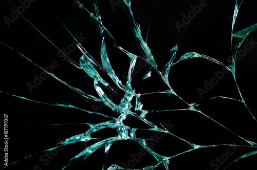 Broken security glass close up macro shot isolated on black background.