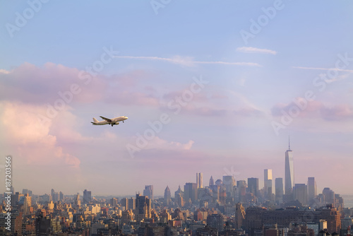 View of midtown of Manhattan on sunset. Plane flies over skyscrapers of New York City, Manhattan