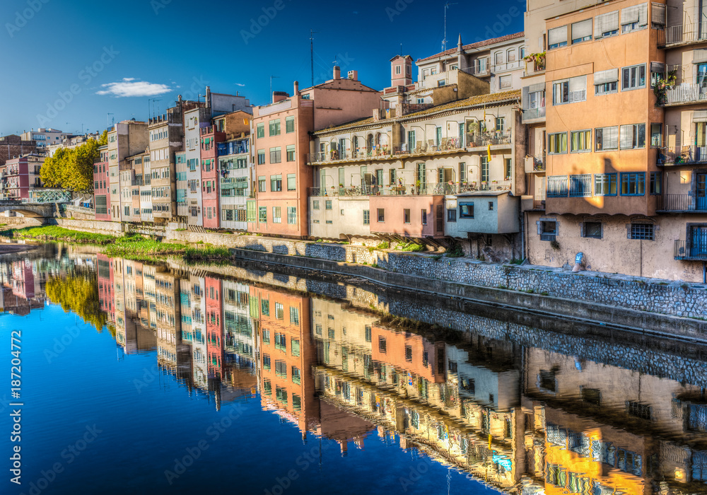 Colorfull river-front houses lining the Onyar river, mostly built on top of old medieval defense walls, Girona, Catalonia, Spain
