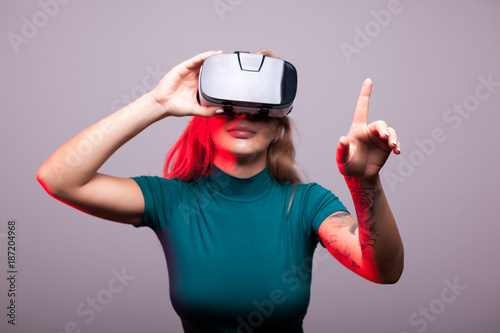 Woman wearing a VR headset in studio photo on gray background