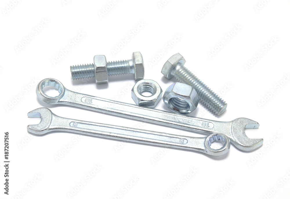 Bolts, nuts and a wrench on a white background close-up Bolts, nuts and a wrench on a white background close-up