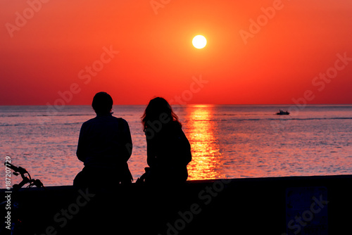 Summer. Sea. Sunset on the Black sea. Sochi. Krasnodar Krai. Russia. Couple admiring the sunset on the beach.