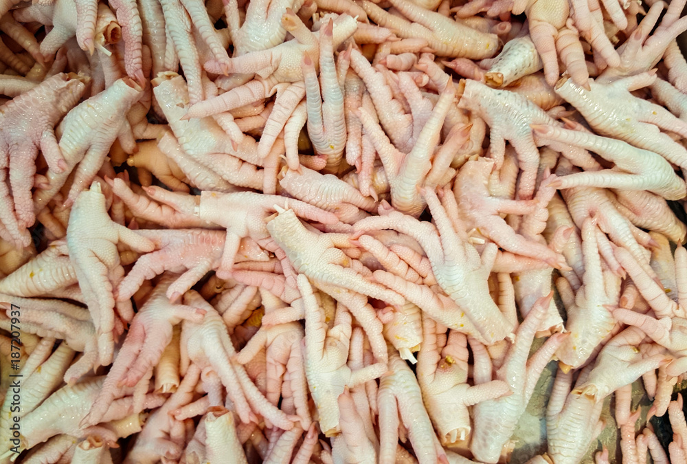 Group of raw chicken feet in the market for sale. Food.