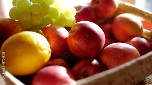 Woman take apple from the basket. Closeup shot.