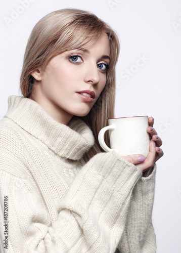 Blonde woman drinking a cap of hot chocolate