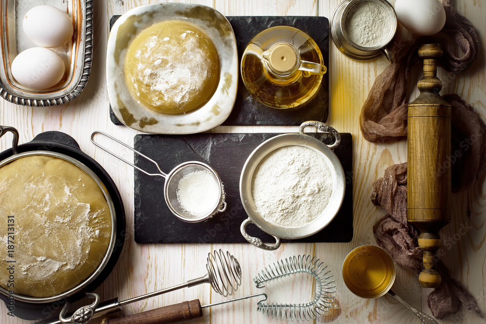 Dough with flour on an old background in a composition with kitchen accessories Dough with flour on an old background in a composition with kitchen accessories
