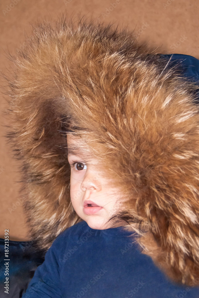 cute little boy in a hood with natural fox fur and raccoon cute little boy in a hood with natural fox fur and raccoon