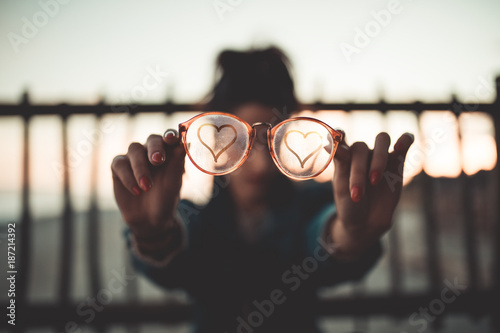 Simbolo del Cuore sugli occhiali di vetro appannato tenuti in mano da una ragazza. photo