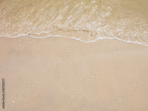 Wide angle view of smooth wet white sand with a small tide washing ashore. Hua Hin, Thailand. Travel and nature backgrounds concept.