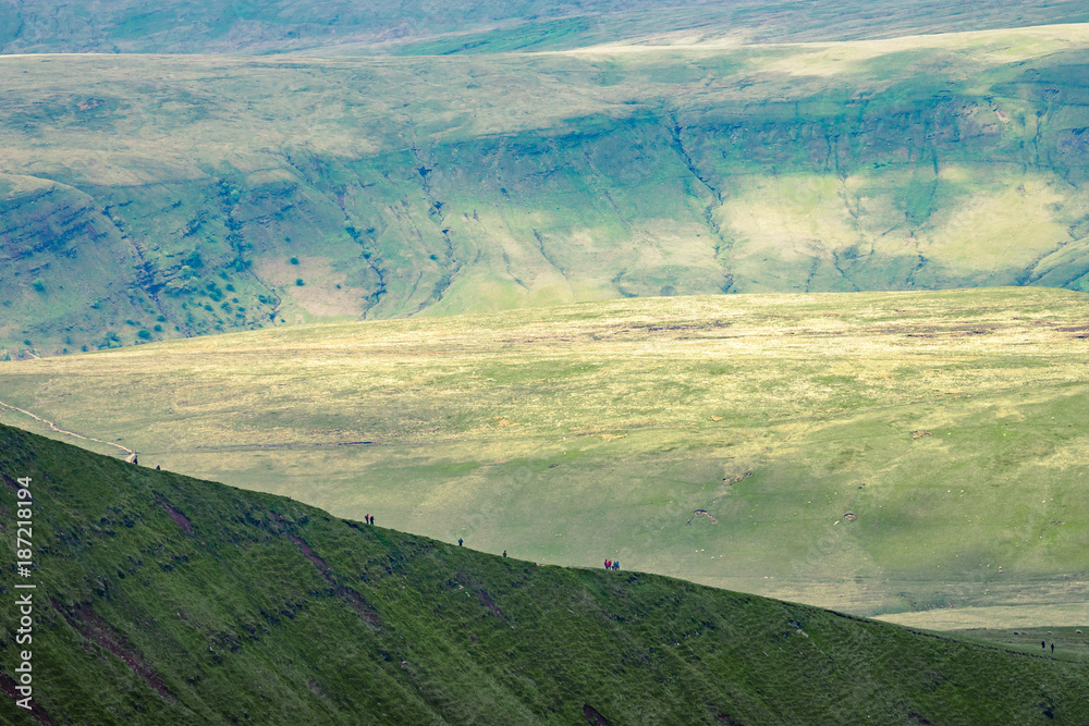 People in distance hiking up on the hillside near to Pan Y Fan in Brecon Beacons, Wales
