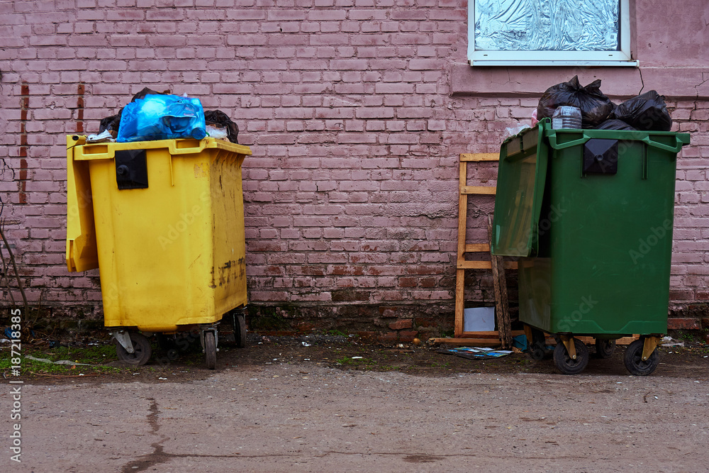 Full plastic garbage cans on the street of the big city Full plastic garbage cans on the street of the big city